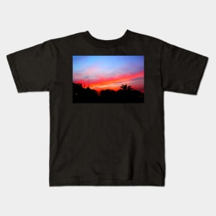 Stunning red purple sunset over a coastal town Kids T-Shirt